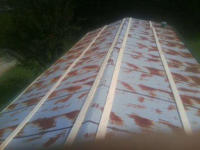 Rusted metal roof panels with new wood purlins before replacement — Storm Damage Roof Repair in Lolita by Roofing Brothers