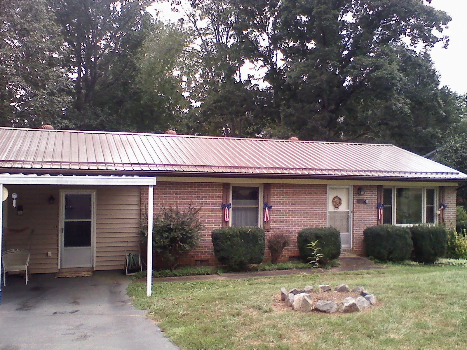 Bronze metal roof and carport on a brick ranch home — Roof Repair work by our crew in Lolita