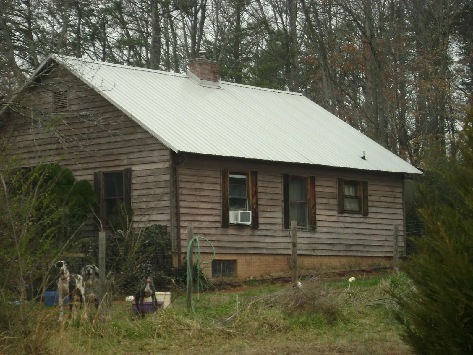 White metal roof on an old wood sided farmhouse, from a Metal Roof Installation job in Lolita